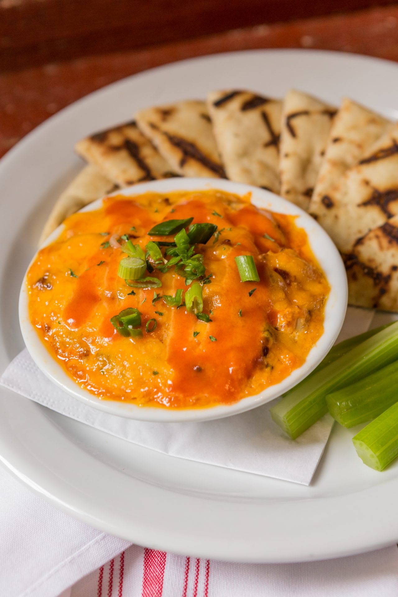 Image of Tailgate Buffalo Dip - Shredded Chicken, Blended Cheeses, Buffalo Sauce, Bleu Cheese Crumbles, Pita Chips, Celery, Carrots

